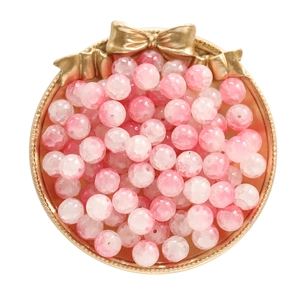 Detailed view of pink crackle glass loose beads for DIY jewelry in a gold tray