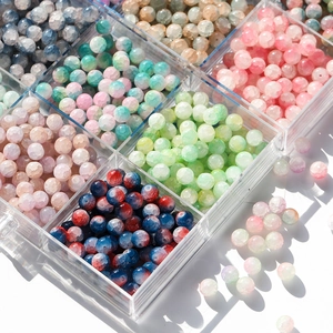Detailed view of colorful 10mm cracked glass beads stored in a clear plastic organizer box