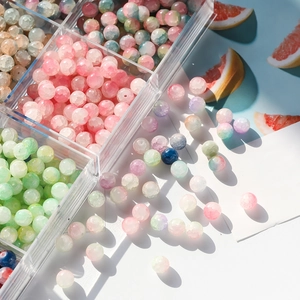 Detailed view of 10mm frosted ice crack glass beads in a clear storage box for DIY jewelry