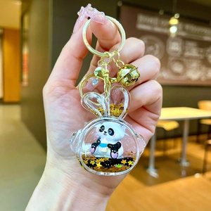 Detail of panda keychain with golden stars and sequins inside a rabbit-shaped resin case