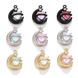 Nahaufnahme von Mond- und Herzanhängern mit Opalsteinen in Schwarz, Silber und Gold