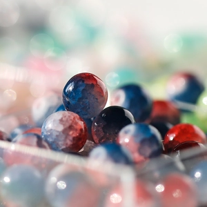 Macro shot of 10mm glass beads with starry red and blue polar light textures for DIY jewelry