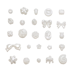 Makroaufnahme von perlmuttweißen Resin-Anhängern wie Rosen und Schleifen für DIY-Schmuck