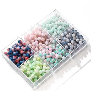 Macro detail of 10mm frosted ice crackle glass beads in a 6-grid acrylic storage box