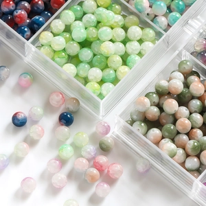 Close-up of 10mm frosted ice-cracked glass beads in a clear organizer for DIY jewelry