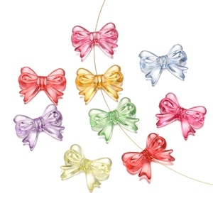 Close-up of colorful acrylic bow beads threaded on a wire for DIY jewelry making
