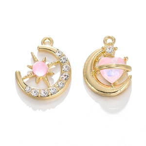 Details von goldenen Mondanhängern mit rosa Kristallen und Sternakzenten auf Weiß