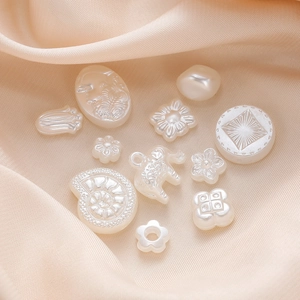 Cremeweiße ABS Perlen in Blumenform für DIY Schmuckherstellung auf Seidenstoff