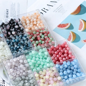 Close-up of 10mm frosted glass beads organized in a transparent 12-slot storage box