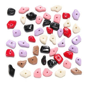 Detailed view of colorful irregular acrylic beads with central holes for DIY jewelry making