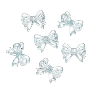 Macro shot of six translucent light blue acrylic bow charms for DIY jewelry making crafts