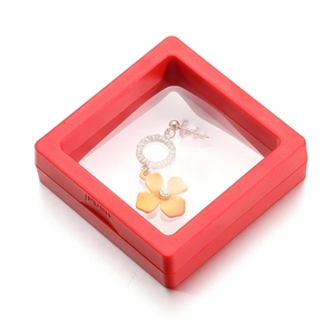 Detailed macro view of yellow floral earrings inside a red PE film display suspension box