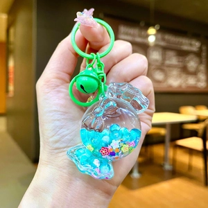Detail of candy-shaped liquid keychain with blue fluid and colorful glitter accents