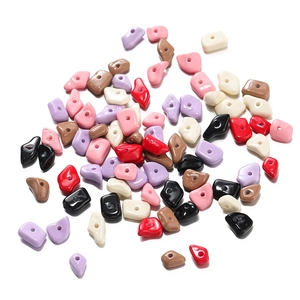 Close-up of irregular acrylic colored beads with drill holes for DIY jewelry making