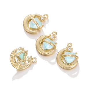 Detail von goldfarbenen Mond- und Herzanhängern mit blauem Kristall für DIY-Schmuck