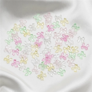 Colorful translucent resin bow accessories for nail art and DIY on white satin fabric