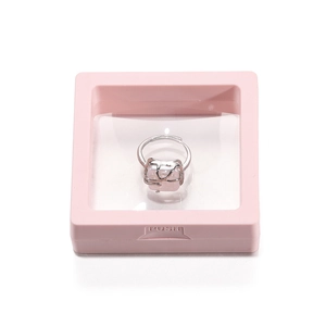 Detail of pink PE film suspension box holding a silver ring with pink gemstone