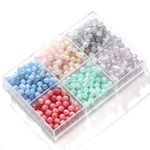 Macro detail of 10mm frosted ice crack glass beads in a six-grid acrylic storage box