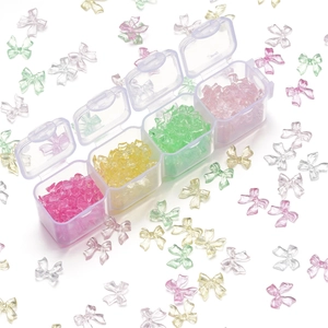 Colorful resin bow nail art charms stored in a clear four-grid organizer box