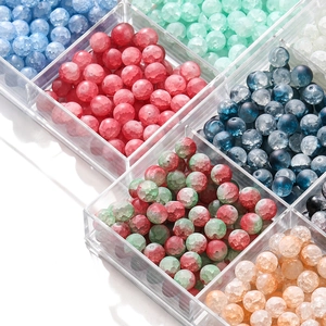 Macro shot of 10mm frosted ice crackle glass beads sorted in a transparent storage box
