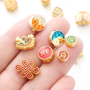 Macro shot of gold alloy dragon head and lucky charms with enamel details for DIY jewelry