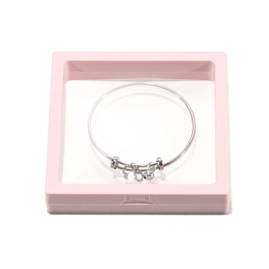 Pink PE film floating display box with a silver charm bracelet and bow detail
