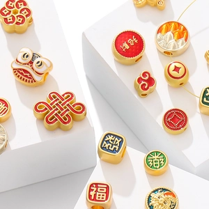 Macro shot of gold-plated lucky charm beads with colorful enamel Chinese folk patterns