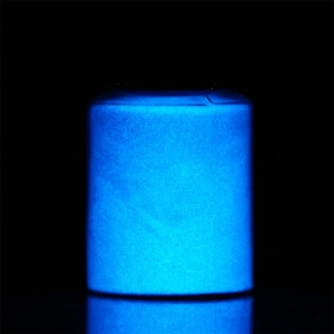 Luminous powder in a jar glowing bright blue in the dark for epoxy and paint crafts