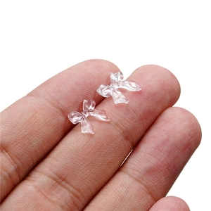 Close-up of translucent resin bow nail charms for DIY manicure art and crafts