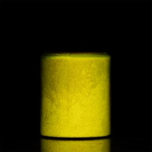Glow-in-the-dark luminous powder glowing in vibrant yellow color against black background