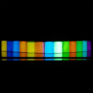 Detailed view of 12-color glow in the dark powder bottles with vibrant luminous reflection