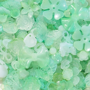 Detail van mintgroene acrylkralen in roos- en strikvorm voor DIY-sieraden maken