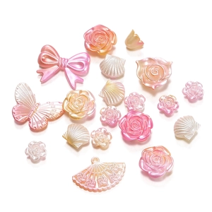 Detailweergave van parelmoer acryl kralen in strik- en roosvorm voor DIY sieraden