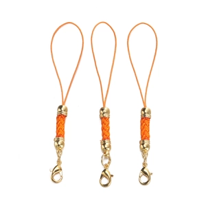 Close-up of three orange braided DIY lanyards with golden lobster clasps and metal beads