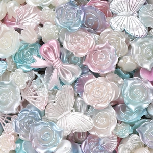 Macro-opname van diverse acryl parelmoer kralen in bloem- en vlindervormen voor DIY-werk