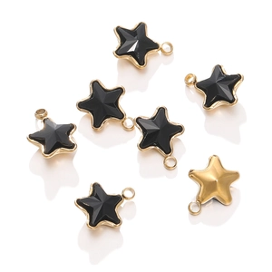 Macro detail of seven star-shaped stainless steel charms with black enamel and 18k gold plating