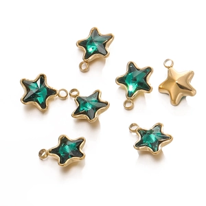 Macro view of gold-plated 18k star pendants with green crystal inlay and smooth back