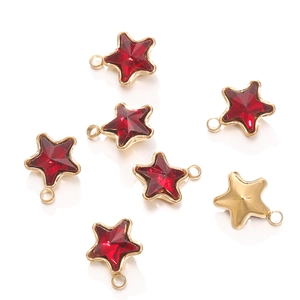 Detail of star-shaped 18k gold pendants with red faceted crystals and smooth metal back