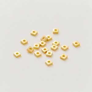 Vista macro de cuentas espaciadoras cuadradas bañadas en oro de 18k para joyería DIY