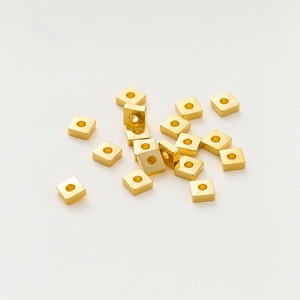 Vista macro de cuentas espaciadoras cuadradas bañadas en oro de 18k para joyería DIY