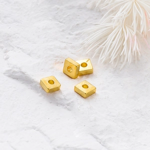 Primer plano de cuatro cuentas espaciadoras cuadradas bañadas en oro 18k para joyería DIY