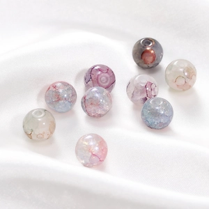 Détails macro de perles en verre marbré 10mm avec feuilles d'or sur satin de soie