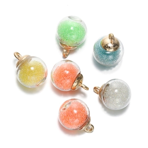 Détail de pendentifs boules en verre transparent avec billes colorées et métal doré