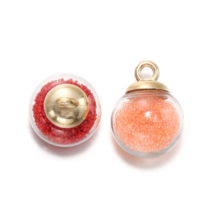 Détail de pendentifs boules en verre avec perles rouges et orange et embouts dorés