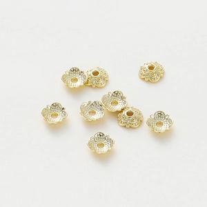 Detailed macro view of 18k gold plated flower bead caps with hollow filigree for DIY jewelry