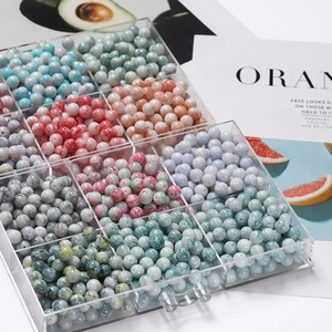 Détail macro de perles de verre colorées de 10mm dans une boîte de rangement à 9 cases