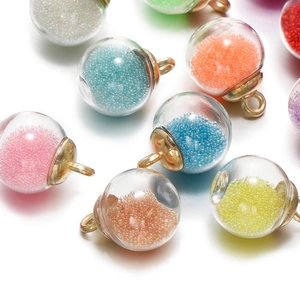 Détail macro de pendentifs en verre avec perles colorées et anneaux en métal doré
