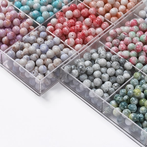 Vue macro de perles en verre marbré de 10mm dans une boîte pour bijoux artisanaux