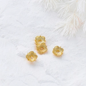 Close-up of 18k gold plated hollow flower bead caps with textured grid petal design