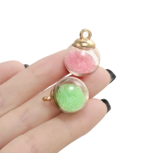 Détail macro de mini breloques en verre avec micro-perles roses et vertes pour bijoux DIY
